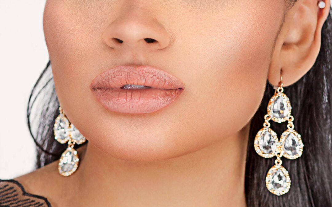 Glamorous woman with bold makeup and statement earrings, close-up portrait.
