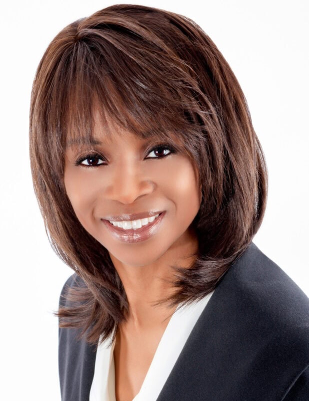 BLOG 65 Smiling professional woman with shoulder-length hair in a business suit.